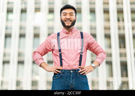 Joyeux chinois dans des vêtements décontractés souriant à l'appareil photo Banque D'Images