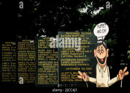 Une effigie du président élu Ferdinand Marcos Jr se tient avec les noms sculptés des héros et des martyrs qui ont combattu vaillamment le régime Marcos pendant la loi martiale. Divers groupes prennent part à un mouvement lors de la célébration de 124th année de la Journée de l'indépendance des Philippines. Des militants et des défenseurs des droits de l'homme ont organisé une activité de la Journée de l'indépendance axée sur l'état de liberté dans le pays, qui traite de la liberté de la presse, de la liberté économique et de la souveraineté nationale, qui est censée être menacée par la nouvelle administration entrante de Ferdinand Marcos Jr Banque D'Images