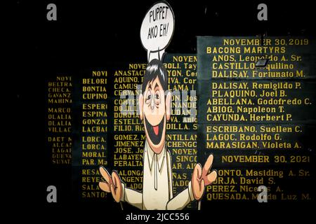Une effigie du président élu Ferdinand Marcos Jr se tient avec les noms sculptés des héros et des martyrs qui ont combattu vaillamment le régime Marcos pendant la loi martiale. Divers groupes prennent part à un mouvement lors de la célébration de 124th année de la Journée de l'indépendance des Philippines. Des militants et des défenseurs des droits de l'homme ont organisé une activité de la Journée de l'indépendance axée sur l'état de liberté dans le pays, qui traite de la liberté de la presse, de la liberté économique et de la souveraineté nationale, qui est censée être menacée par la nouvelle administration entrante de Ferdinand Marcos Jr (Photo de Ryan Eduard Ben Banque D'Images