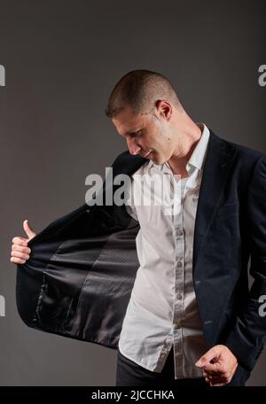 Un jeune homme dans une veste noire posant dans un studio. Banque D'Images