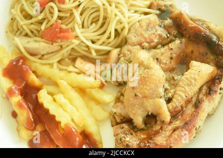 Steak de poulet grillé au poivre noir sauce épicée avec frites et saucisses spaghetti frites sur l'assiette Banque D'Images