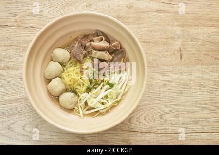 Nouilles aux œufs jaunes chinoises bouillies avec bœuf braisé et boulettes de viande dans la soupe du bol Banque D'Images