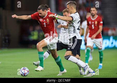 BUDAPEST, HONGRIE - JUIN 11 : Joshua Kimmich d'Allemagne (r) et Nico Schlotterbeck d'Allemagne (R2) défient Adam Szalai de Hongrie lors de la Ligue des Nations de l'UEFA Un match du Groupe 3 entre la Hongrie et l'Allemagne à l'arène de Puskas sur 11 juin 2022 à Budapest, Hongrie. Banque D'Images