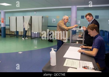 (220612) -- HENIN-BEAUMONT, 12 juin 2022 (Xinhua) -- Un résident lance son bulletin de vote dans un bureau de vote à Henin-Beaumont, en France, au 12 juin 2022. Le premier tour des élections législatives françaises de 2022 a débuté dimanche en France métropolitaine (la région du pays géographiquement en Europe) pour permettre aux électeurs d'élire 577 membres pour l'Assemblée nationale. (Photo de Sébastien Courdji/Xinhua) Banque D'Images