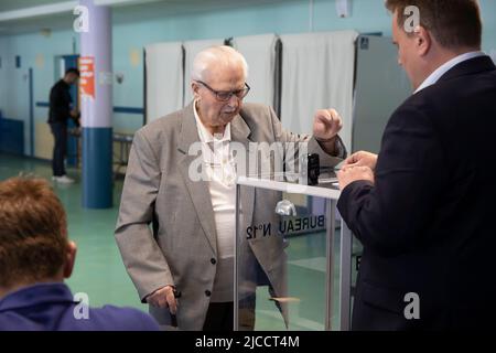 (220612) -- HENIN-BEAUMONT, 12 juin 2022 (Xinhua) -- Un résident lance son bulletin de vote dans un bureau de vote à Henin-Beaumont, en France, au 12 juin 2022. Le premier tour des élections législatives françaises de 2022 a débuté dimanche en France métropolitaine (la région du pays géographiquement en Europe) pour permettre aux électeurs d'élire 577 membres pour l'Assemblée nationale. (Photo de Sébastien Courdji/Xinhua) Banque D'Images