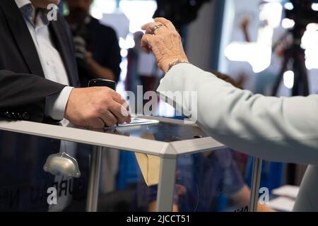 (220612) -- HENIN-BEAUMONT, 12 juin 2022 (Xinhua) -- Un résident lance le scrutin dans un bureau de vote à Henin-Beaumont, en France, au 12 juin 2022. Le premier tour des élections législatives françaises de 2022 a débuté dimanche en France métropolitaine (la région du pays géographiquement en Europe) pour permettre aux électeurs d'élire 577 membres pour l'Assemblée nationale. (Photo de Sébastien Courdji/Xinhua) Banque D'Images