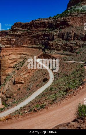 Route de terre au fond du canyon parmi les formations géologiques en couches de roches rouges. ÉTATS-UNIS Banque D'Images