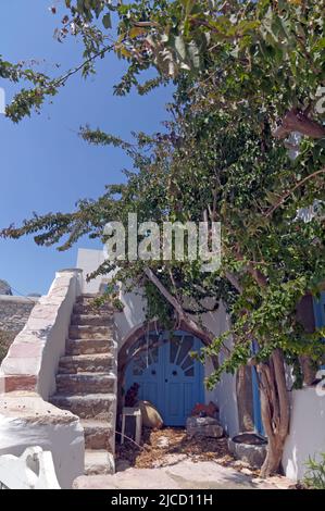 Vue sur une maison cachée par des arbres, dans le village de montagne Megalo Chorio, Tilos, Dodécanèse, Rhodes, Grèce. Mai 2022. Ressort Banque D'Images