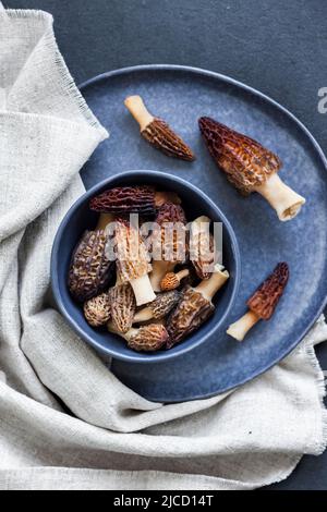 Champignons de Morel dans un bol bleu Laissez à plat Banque D'Images