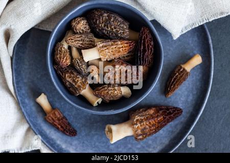 Champignons de Morel dans un bol bleu Laissez à plat Banque D'Images