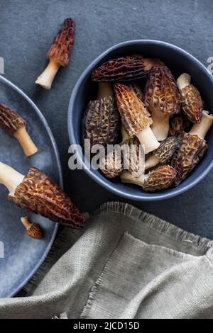 Champignons de Morel dans un bol bleu Laissez à plat Banque D'Images