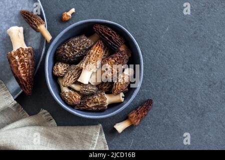 Champignons de Morel dans un bol bleu Laissez-vous à plat, copiez l'espace Banque D'Images