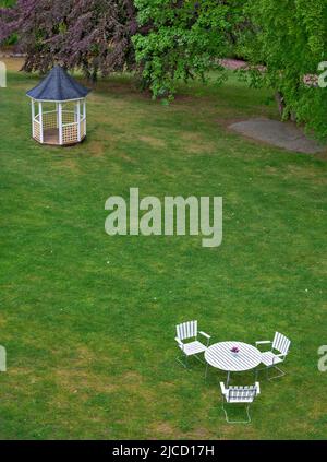 Petit pavillon et groupe de sièges blancs sur une pelouse verte dans un parc en Suède Banque D'Images