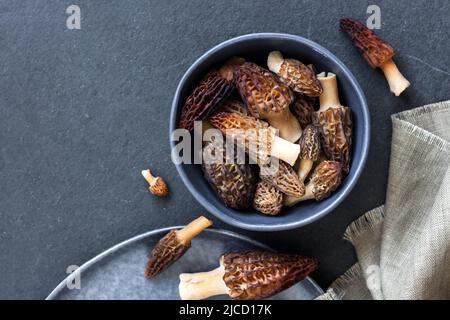 Champignons de Morel dans un bol bleu Laissez-vous à plat, copiez l'espace Banque D'Images