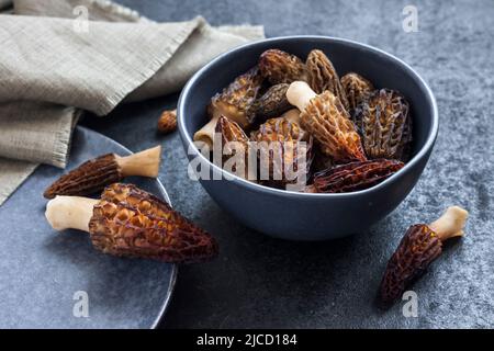 Champignons Morel dans un bol bleu. Gros plan Banque D'Images