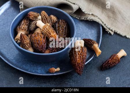 Champignons Morel dans un bol bleu. Gros plan Banque D'Images