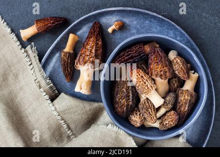 Champignons Morel dans un bol bleu. Pose à plat Banque D'Images