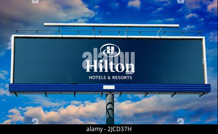 POZNAN, POL - 1 MAI 2022 : panneau publicitaire affichant le logo de Hilton Hotels and Resorts, une marque mondiale d'hôtels et de centres de villégiature multiservices Banque D'Images