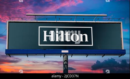 POZNAN, POL - 1 MAI 2022 : panneau publicitaire affichant le logo de Hilton Worldwide Holdings Inc., une société d'accueil qui gère et franchisage Banque D'Images