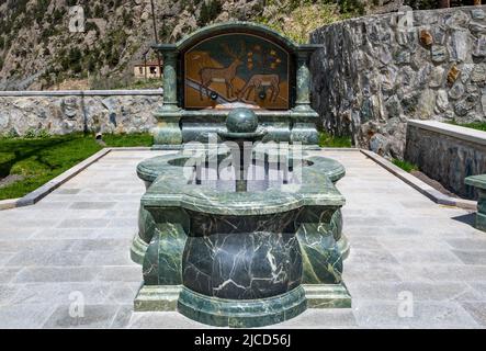 Une fontaine sculptée en pierre de serpentin verte. Le monastère de Dariali. Montagnes du Caucase. Kazbegi, la République de Géorgie. Banque D'Images