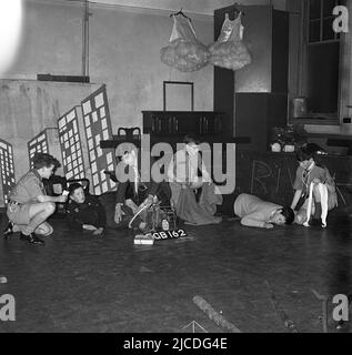 1960s, historique, plusieurs scouts de garçon dans une salle d'école faisant des exercices de premiers secours, dans le cadre de leur formation, pour obtenir leurs badges de sécurité, Angleterre, Royaume-Uni. Les premiers soins sont une compétence importante pour chaque scout, comme avec une certaine connaissance de celui-ci, ils sont en mesure de fournir des soins et une assistance immédiats à ceux qui sont blessés ou qui deviennent malades. Banque D'Images