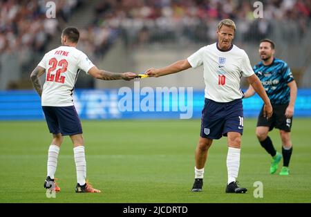 Teddy Sheringham (à droite), de l'Angleterre, passe le brassard du capitaine au coéquipier Liam Payne lors du match de football Aid for UNICEF au London Stadium, à Londres. Date de la photo: Dimanche 12 juin 2022. Banque D'Images