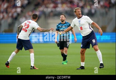 Teddy Sheringham (à droite), de l'Angleterre, passe le brassard du capitaine au coéquipier Liam Payne lors du match de football Aid for UNICEF au London Stadium, à Londres. Date de la photo: Dimanche 12 juin 2022. Banque D'Images