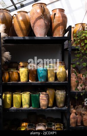 Beaucoup de cruches et vases en argile uniques et colorés faits à la main de formes diverses sur l'étagère dans le marché local Banque D'Images