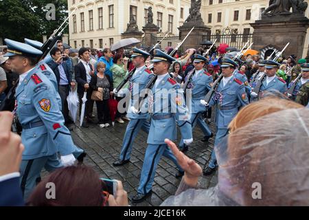 Les touristes regardent sous la pluie la cérémonie de la relève de la garde du château (Hradní stráž) devant le château de Prague sur la place Hradčanské à Prague, en République tchèque. Banque D'Images