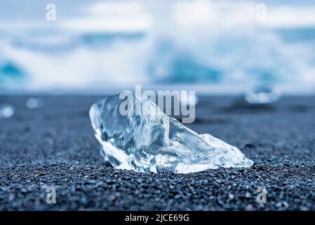 Gros plan d'un beau morceau de glace sur le rivage de sable noir de Diamond Beach Banque D'Images