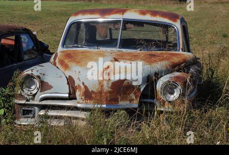 Une vieille voiture rouille est abandonnée dans un champ le long de l'historique route 66 près d'Erick, Oklahoma. Banque D'Images