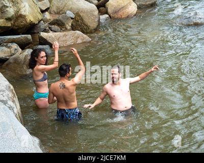 Cisneros, Antioquia, Colombie - 20 février 2022: Amis entrant dans l'eau froide de la rivière entourée de rochers Banque D'Images