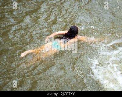 Femme nage dans la rivière près des montagnes Banque D'Images