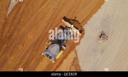 Tir de drone de haut en bas d'un bulldozer travaillant sur le chantier de construction. Photo de haute qualité Banque D'Images
