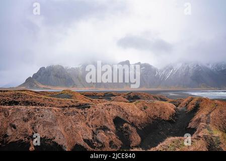 Vue sur l'herbe sur le sable noir contre le cap Stokksnes et la montagne Vestahorn Banque D'Images