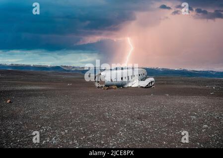 Foudre sur une épave d'avion cassée à la plage de sable noir à Solheimasandur Banque D'Images