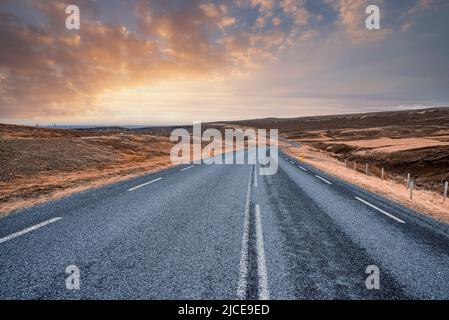 Belle vue sur la route vide au milieu du paysage volcanique contre le ciel pendant le coucher du soleil Banque D'Images