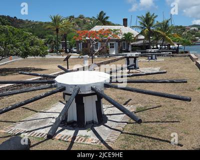 Vue d'un vieux cabestan à Nelson's Dockyard dans le port anglais Antigua avec le cabestan House en arrière-plan Banque D'Images