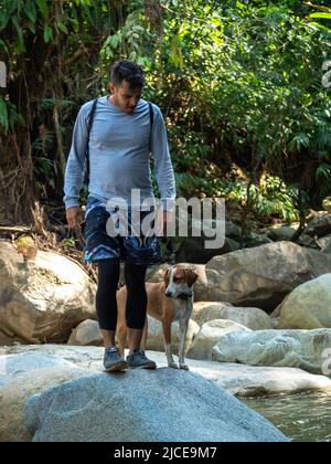 Cisneros, Antioquia, Colombie - 20 février 2022: Homme sud-américain dans un rocher avec son chien Banque D'Images