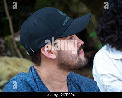 Cisneros, Antioquia, Colombie - 20 février 2022: Backpacker blanc avec capuchon noir dans la forêt près de la rivière Banque D'Images