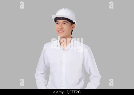 Portrait le jeune homme asiatique est ingénieur portant un casque debout et souriant avec confiance isolé sur fond blanc, beau homme est architecte ou co Banque D'Images