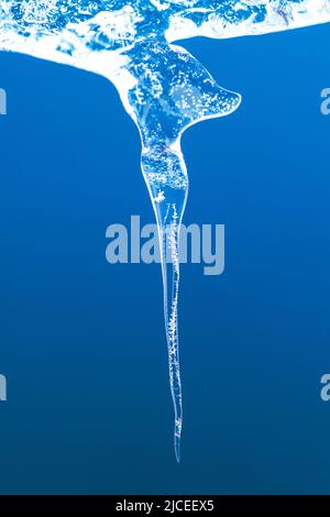 formation de glace fondue sur fond bleu Banque D'Images