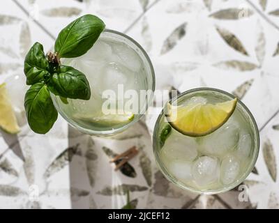 Deux cocktails margarita avec citron vert et basilic sur carreaux imprimés. Orientation de l'horisontal. Vue de dessus Banque D'Images