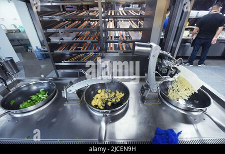 HANGZHOU, CHINE - 13 JUIN 2022 - Un robot cuisant des plats pour les clients dans un restaurant robot du quartier de Xihu à Hangzhou, dans le Zhej de la Chine orientale Banque D'Images