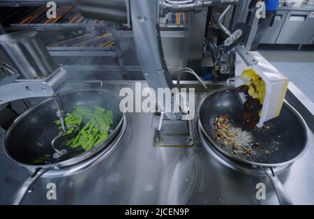 HANGZHOU, CHINE - 13 JUIN 2022 - Un robot cuisant des plats pour les clients dans un restaurant robot du quartier de Xihu à Hangzhou, dans le Zhej de la Chine orientale Banque D'Images