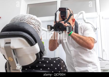 Dentiste photographiant les dents du patient à des fins de dossier médical avant et après la chirurgie dans le cabinet du dentiste Banque D'Images