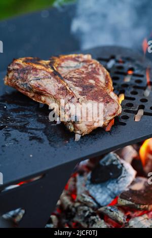 Vue en gros plan sur le steak d'os en T sur le gril (photo avec une faible profondeur de champ) Banque D'Images