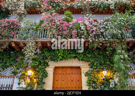 Vue sur une entrée de la maison avec des balcons décorés de fleurs Banque D'Images