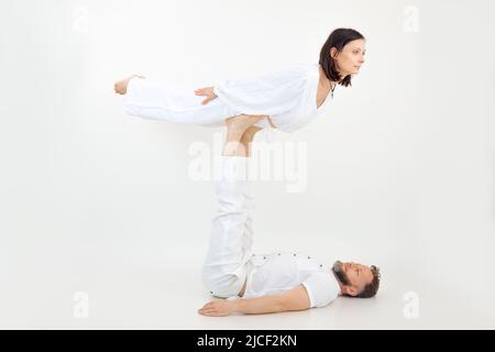 Homme et femme, couple faisant des exercices sportifs, fitness et yoga. Homme tenant une femme sur les jambes, exerçant des postures, confiance Banque D'Images