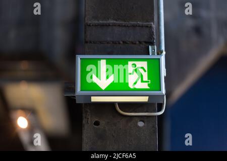 Essen, Allemagne - 26 mars 2022 : panneau de sortie de secours. Flèche pointant vers le bas. Banque D'Images